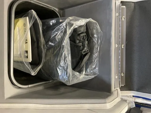 Slide: The Image of Storage compartment in a 2025 Bennington 22SSB-SPS boat with packaged items. - 26