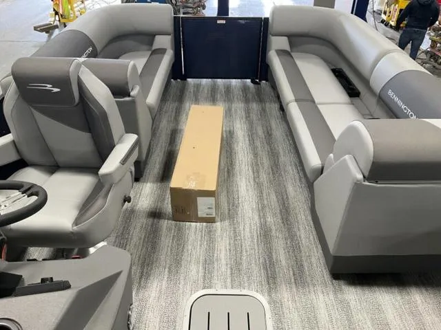 Slide: The Image of 2025 Bennington 22 SSR pontoon boat interior with gray seating and a cardboard box. - 10
