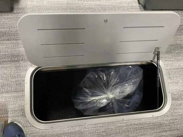 Slide: The Image of Open storage compartment on 2025 Bennington 22 SSR boat with bag inside. - 9