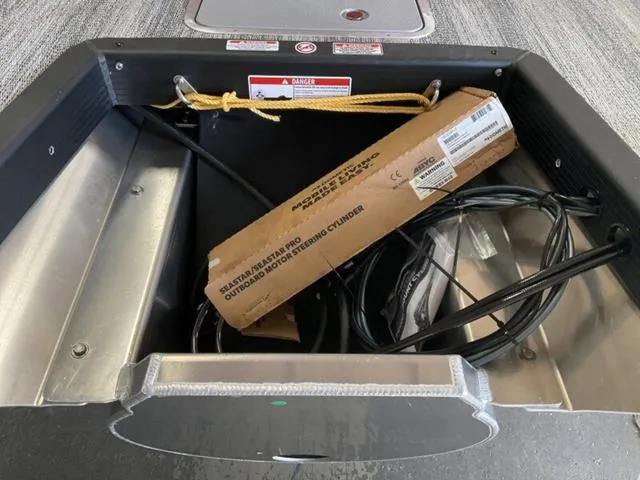 Slide: The Image of Storage compartment of 2025 Bennington 23 SSB boat with cables and a cardboard box. - 11