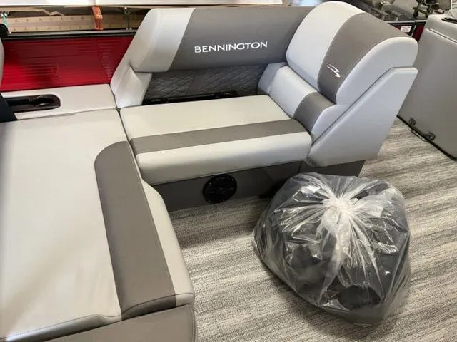 Slide: The Image of 2025 Bennington 23 SSB boat interior with gray seating and plastic-covered item. - 15
