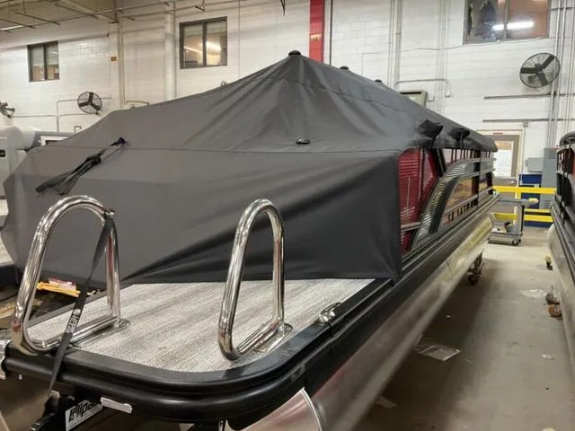 Slide: The Image of 2025 Bennington 23 SSB pontoon boat with cover in a warehouse setting. - 3