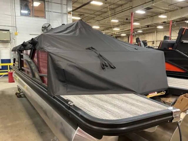 Slide: The Image of 2025 Bennington 23 SSB pontoon boat covered in a warehouse setting. - 5