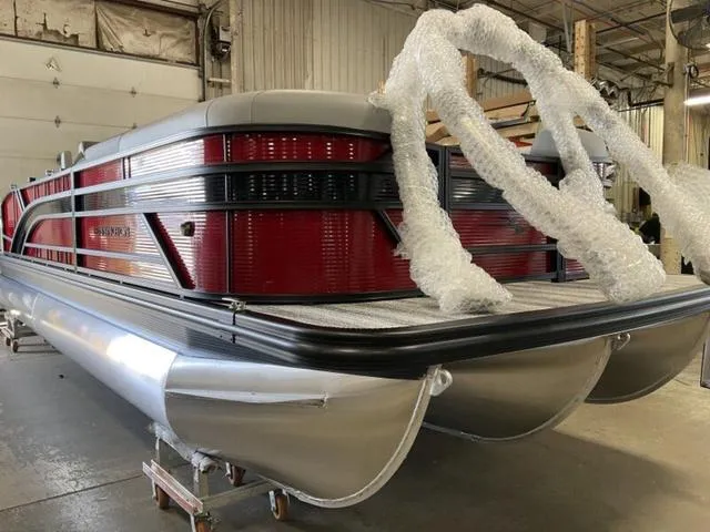 Slide: The Image of 2025 Bennington 23 SSB pontoon boat in a warehouse, partially wrapped in protective material. - 6