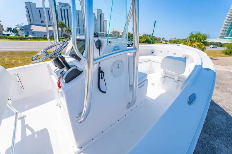 Slide: The Image of 2026 Albury Brothers 23 boat interior with steering console and seating, under clear blue sky. - 13