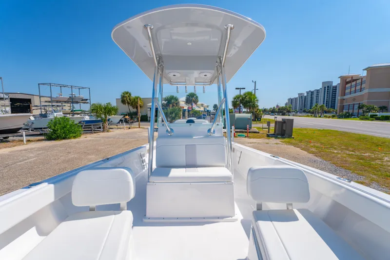 Slide: The Image of 2026 Albury Brothers 23 boat with sleek white interior, parked near a coastal road. - 15