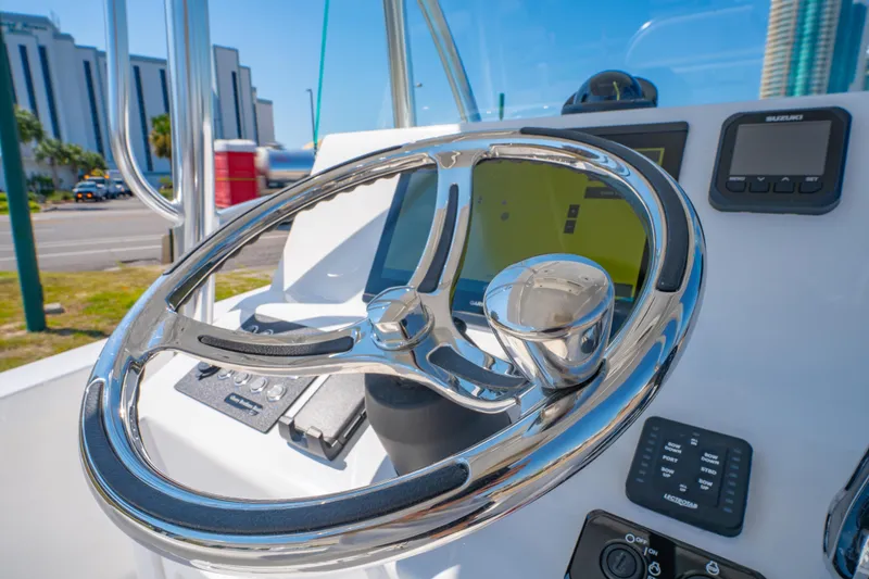 Slide: The Image of Steering wheel of 2026 Albury Brothers 23 boat with modern dashboard controls. - 26