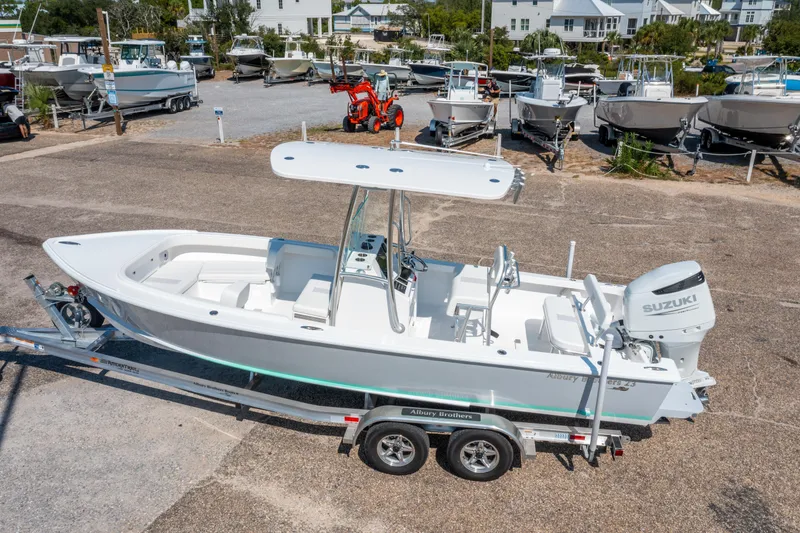 Slide: The Image of 2026 Albury Brothers 23 boat on trailer with Suzuki outboard motor in a marina setting. - 4