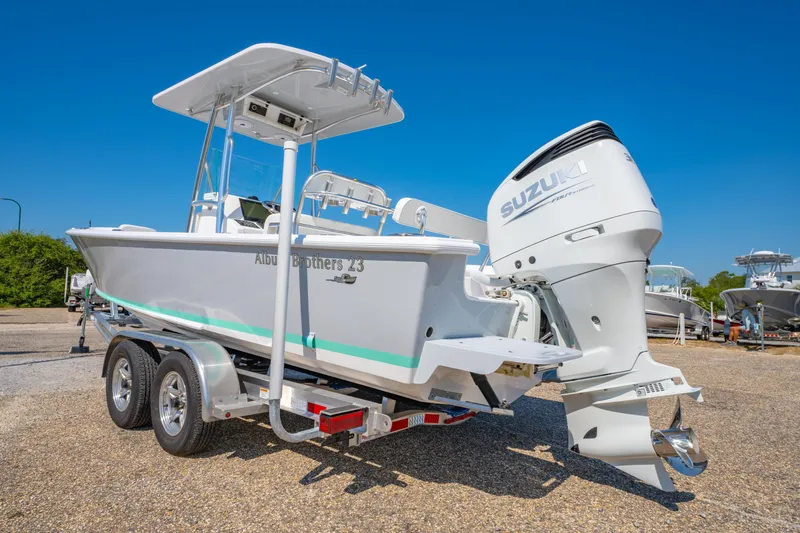 Slide: The Image of 2026 Albury Brothers 23 boat with Suzuki engine on trailer, under clear blue sky. - 9