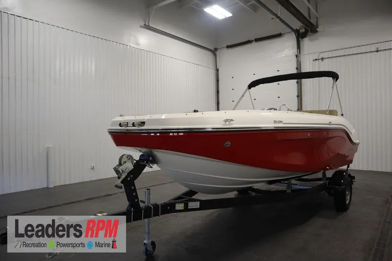 The Image of 2024 Bayliner DX2050 boat in showroom, red and white design, on trailer. - 1
