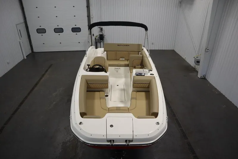 Slide: The Image of 2024 Bayliner DX2050 boat with beige seating in a garage setting. - 15