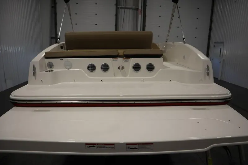 Slide: The Image of 2024 Bayliner DX2050 boat rear view in a warehouse setting. - 20