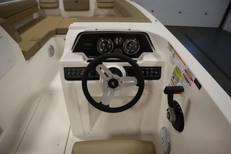 Slide: The Image of 2024 Bayliner DX2050 boat dashboard with steering wheel and control panel. - 21