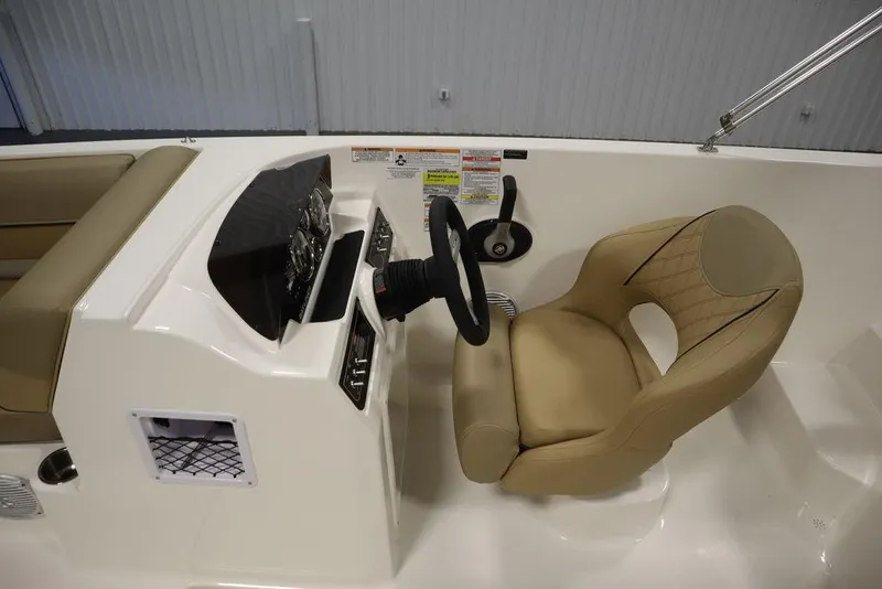 Slide: The Image of 2024 Bayliner DX2050 boat cockpit with steering wheel and beige captain's chair. - 29