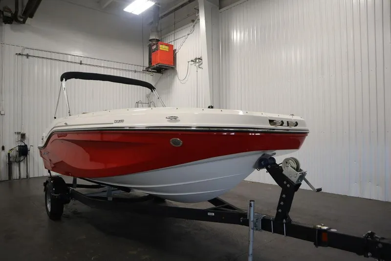 Slide: The Image of 2024 Bayliner DX2050 boat with red hull in indoor storage. - 3