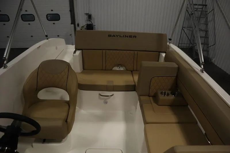 Slide: The Image of 2024 Bayliner DX2050 boat interior with tan seating and steering wheel. - 32