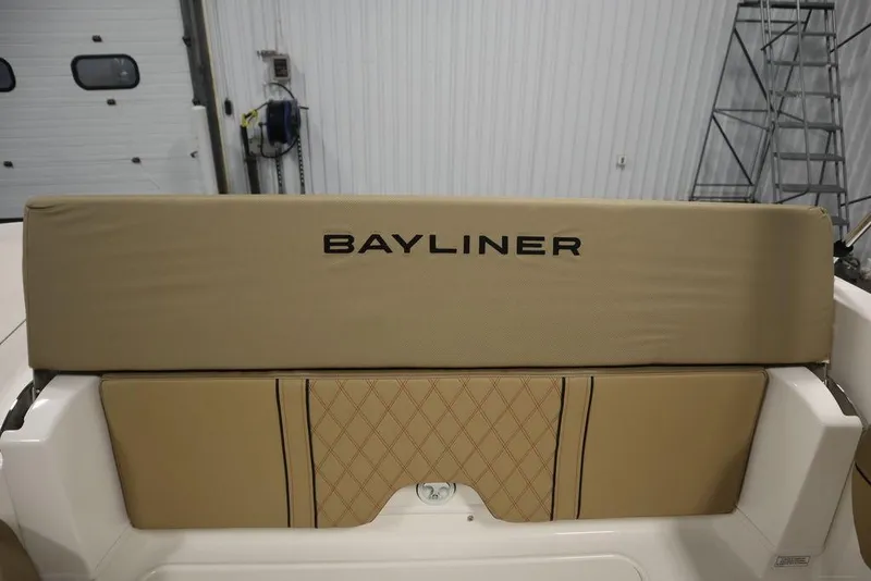 Slide: The Image of 2024 Bayliner DX2050 boat interior with beige seating and logo. - 35