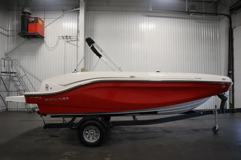 Slide: The Image of 2024 Bayliner DX2050 boat in a warehouse, red and white design on a trailer. - 4