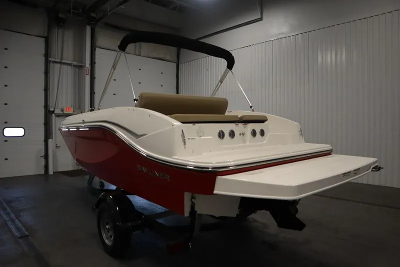 Slide: The Image of 2024 Bayliner DX2050 boat in a garage, featuring a red and white exterior. - 7