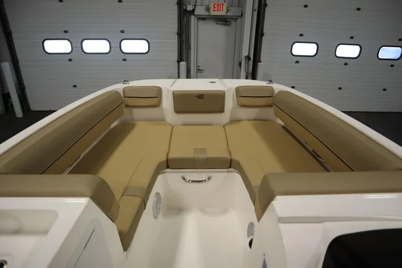 Slide: The Image of 2024 Bayliner DX2050 boat interior with tan seating in a garage setting. - 9