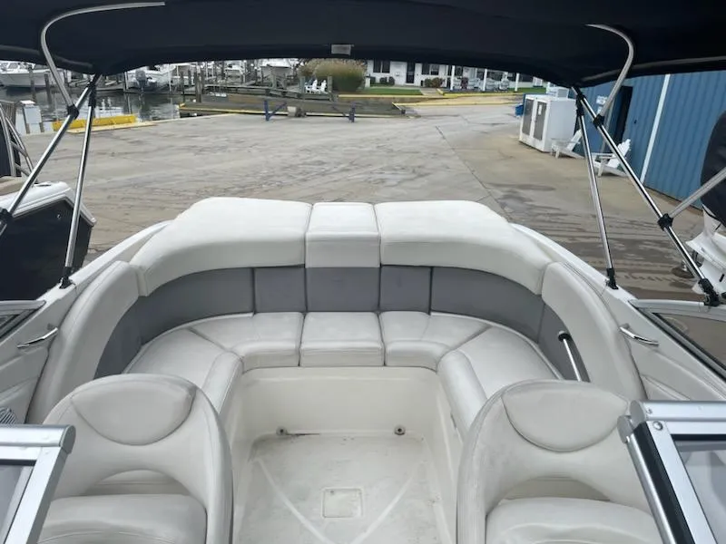 Slide: The Image of 2011 Bayliner 235 Bowrider boat interior with spacious seating at a marina. - 14