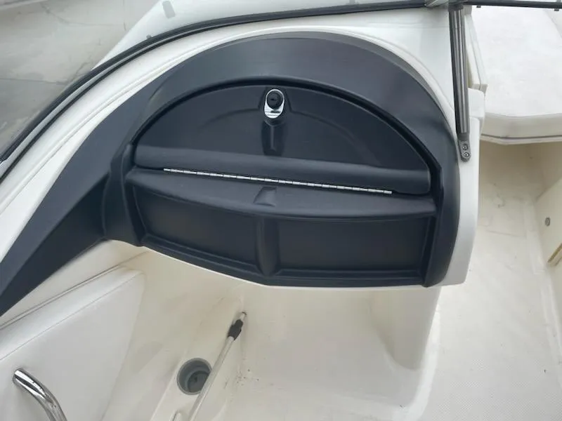 Slide: The Image of 2011 Bayliner 235 Bowrider dashboard with glove compartment and sleek design. - 16