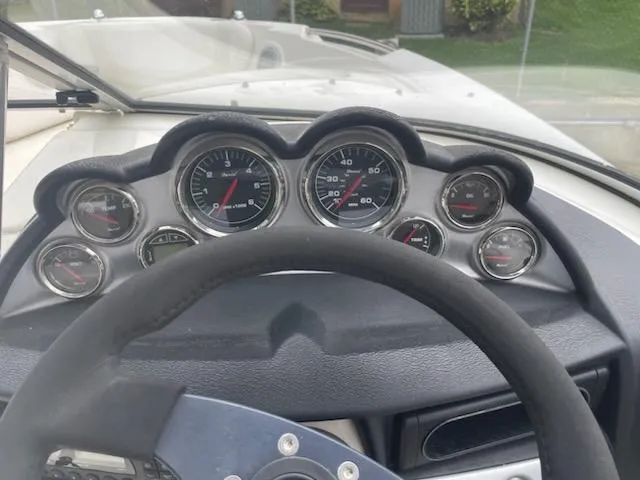 Slide: The Image of Dashboard of a 2011 Bayliner 235 Bowrider boat with multiple gauges and steering wheel. - 19