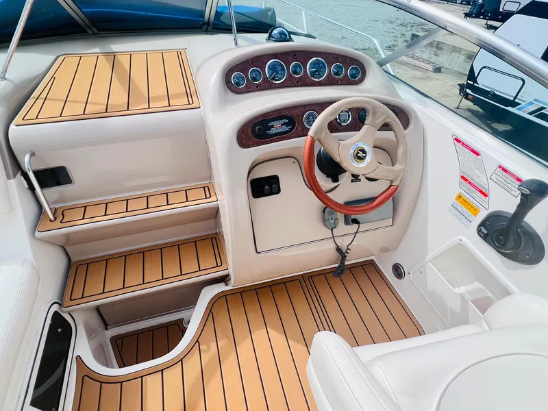 Slide: The Image of 2001 Sea Ray 260 Sundancer boat interior with wood accents and steering wheel. - 10