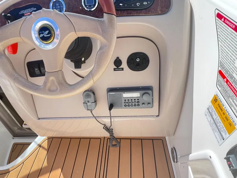 Slide: The Image of 2001 Sea Ray 260 Sundancer helm with steering wheel and radio controls. - 13