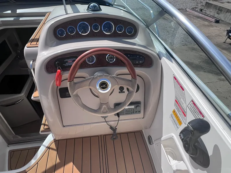 Slide: The Image of 2001 Sea Ray 260 Sundancer helm with gauges and wooden steering wheel. - 14