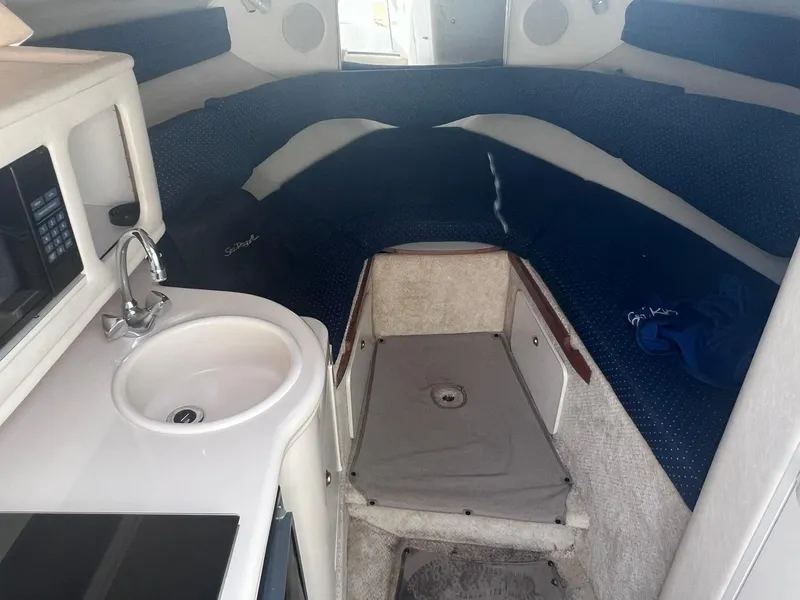 Slide: The Image of 2001 Sea Ray 260 Sundancer cabin interior with sink, microwave, and seating area. - 16