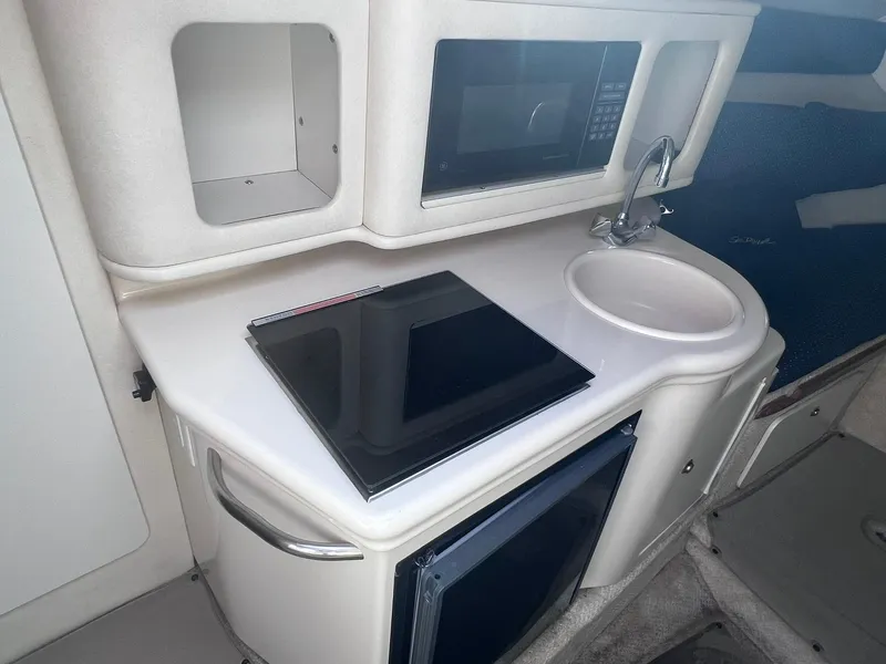 Slide: The Image of 2001 Sea Ray 260 Sundancer galley with microwave, sink, and stove. - 17