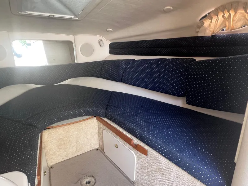 Slide: The Image of 2001 Sea Ray 260 Sundancer cabin interior with blue seating and storage compartments. - 18