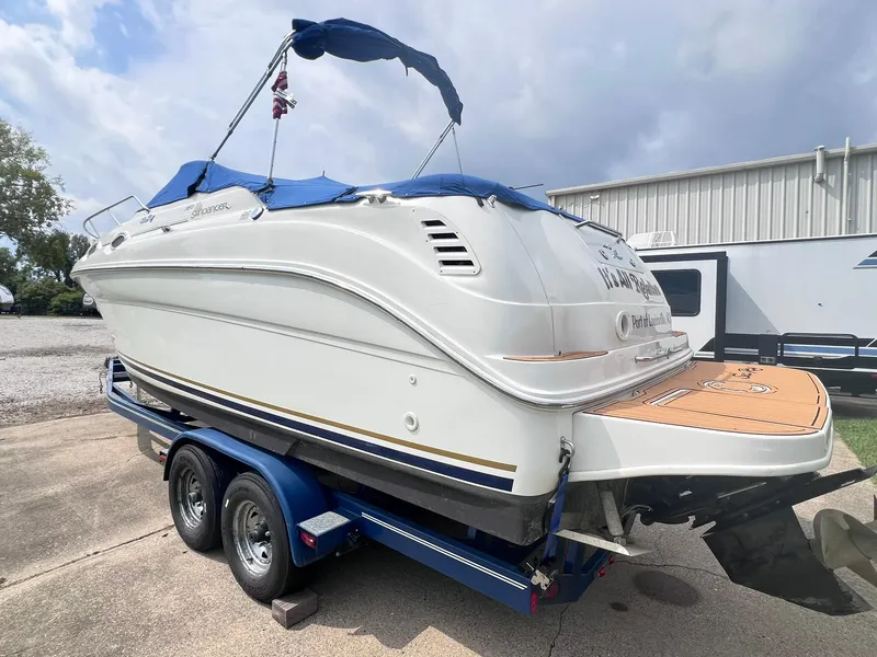 Slide: The Image of 2001 Sea Ray 260 Sundancer boat on trailer, blue cover, parked outdoors. - 2