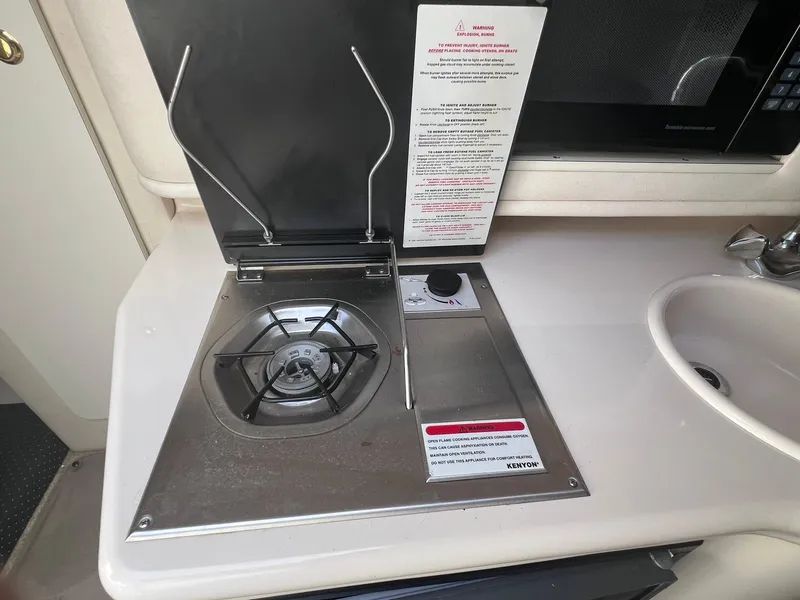 Slide: The Image of 2001 Sea Ray 260 Sundancer boat kitchen with stove and sink. - 22