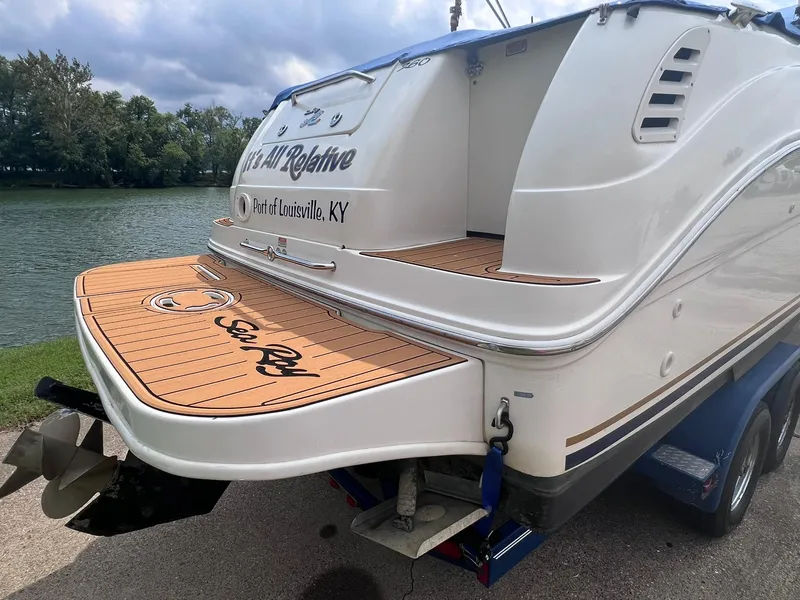 Slide: The Image of 2001 Sea Ray 260 Sundancer boat docked by a scenic river. - 33