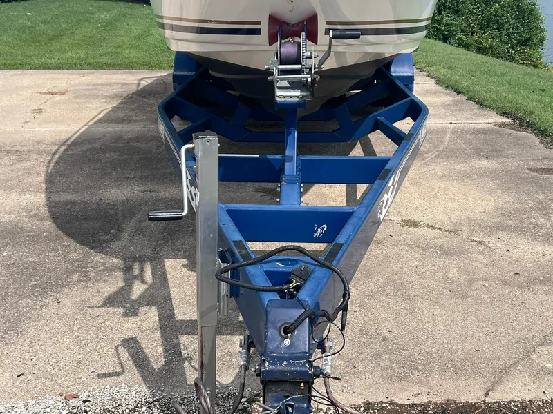 Slide: The Image of 2001 Sea Ray 260 Sundancer on a blue trailer, parked on a concrete driveway. - 37