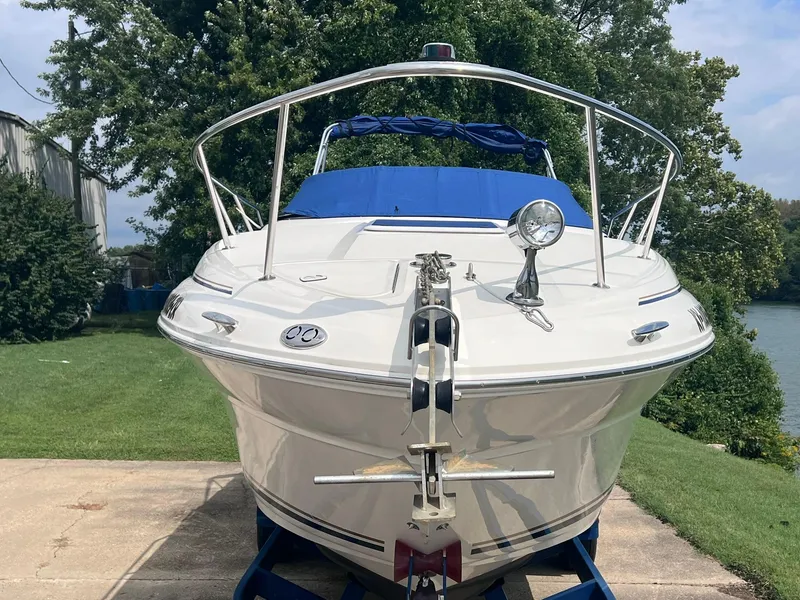 Slide: The Image of 2001 Sea Ray 260 Sundancer boat on trailer, parked on grass, with blue cover. - 38