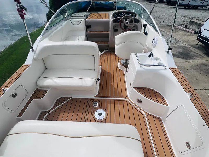 Slide: The Image of 2001 Sea Ray 260 Sundancer boat interior with white seating and wood flooring. - 5