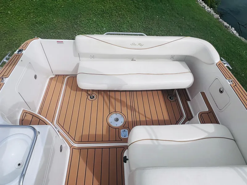 Slide: The Image of 2001 Sea Ray 260 Sundancer boat interior with white seating and teak flooring. - 9