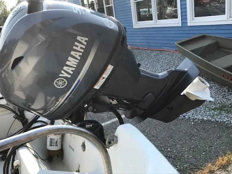 Slide: The Image of Yamaha outboard motor on 1988 Boston Whaler 170 Montauk boat, parked near blue building. - 10