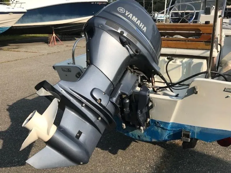 Slide: The Image of 1988 Boston Whaler 170 Montauk with Yamaha outboard motor, docked on pavement. - 2