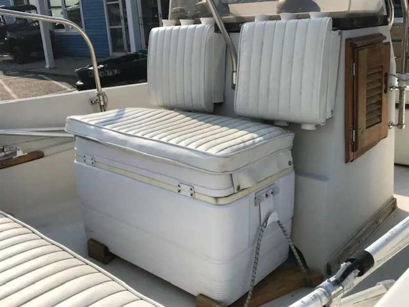 Slide: The Image of 1988 Boston Whaler 170 Montauk boat interior with white cushioned seating. - 7