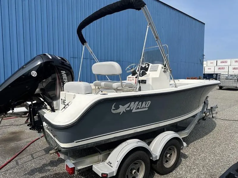 Slide: The Image of 2019 Mako 180 CC boat on trailer, parked near blue building. - 12