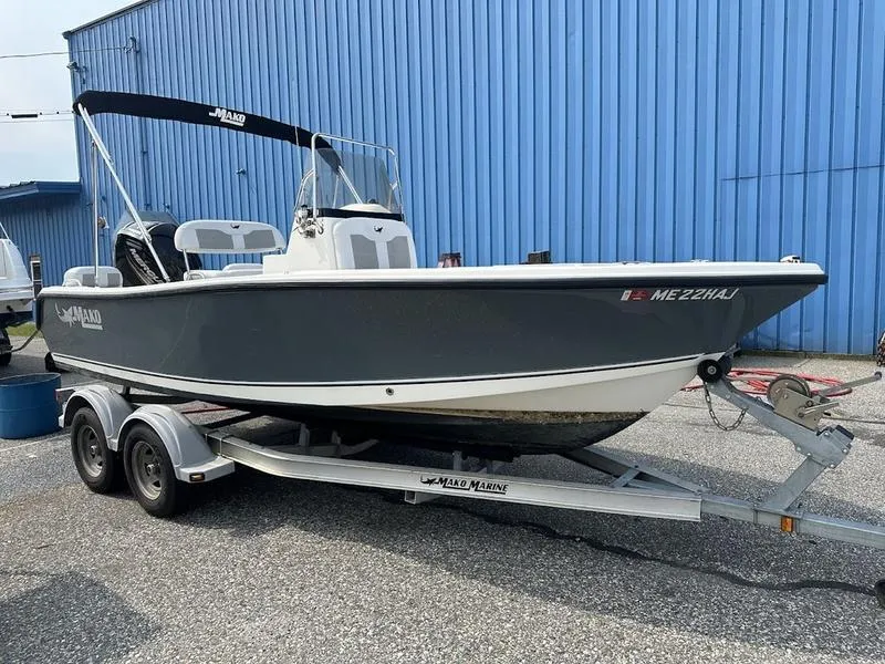Slide: The Image of 2019 Mako 180 CC boat on trailer, parked near blue building. - 8