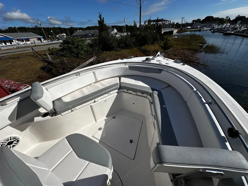 Slide: The Image of 2021 Robalo R242 Center Console boat interior with seating and storage, docked near a marina. - 14