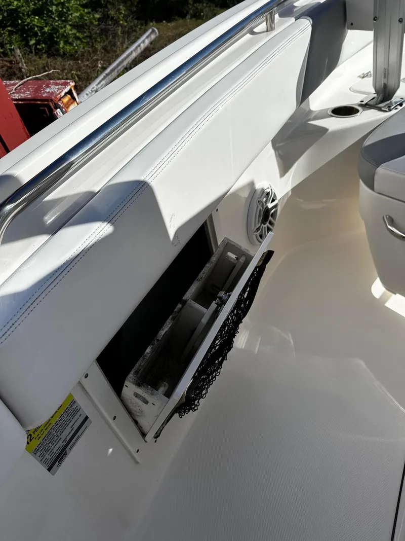 Slide: The Image of 2021 Robalo R242 Center Console boat interior with storage compartment and speaker. - 15