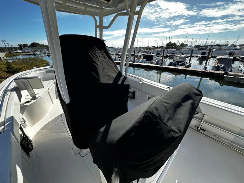 Slide: The Image of 2021 Robalo R242 Center Console boat with covered seats, docked at a marina. - 16