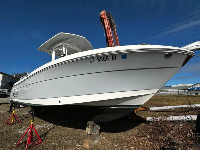 Slide: The Image of 2021 Robalo R242 Center Console boat on stands, clear sky background. - 2