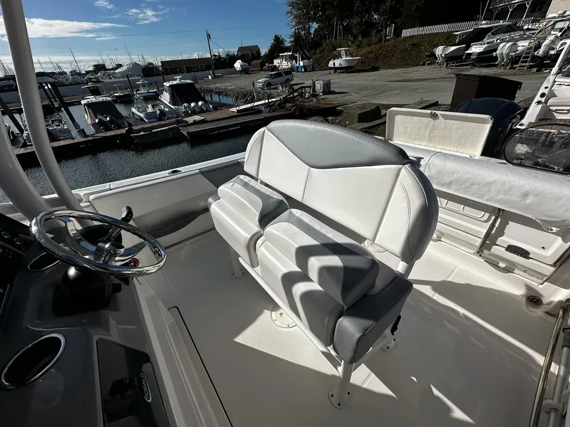 Slide: The Image of 2021 Robalo R242 Center Console boat interior with seating and steering wheel at marina. - 20